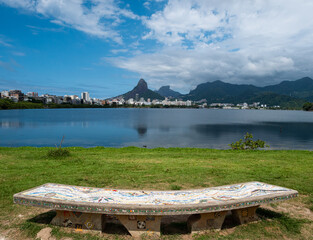 A mosaic bench, inspired by Park Güell in Barcelona, in front of the Lagoa Rodrigo de Freitas in Rio de Janeiro. Dos Hermanos mountains in background.