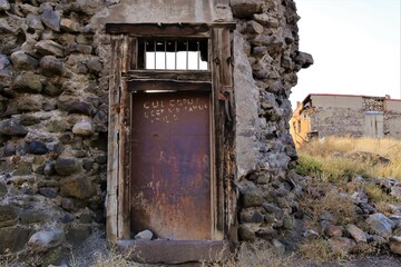 An old door and a demolished wall near Erzurum Castle in Turkey.
(Turkish: Erzurum Kalesi).
Turkey travel.
Islamic ancient building.