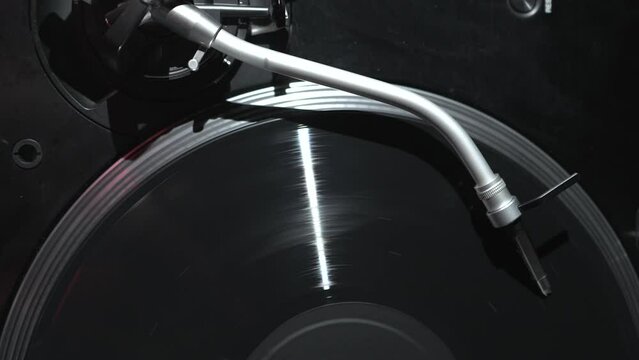 DJ turntable plays vinyl record with classic music. Hip hop disc jockey record player filmed from above