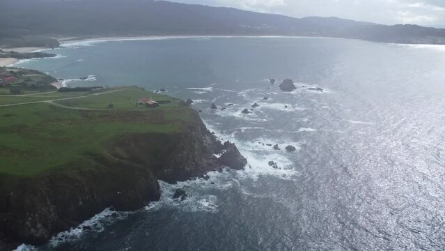 Cliff in front of lanzada beach in galicia in north spain on the atlantic ocean filmed with a drone