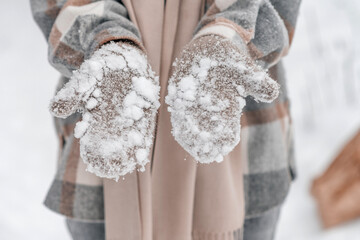 Women's hands in mittens to hold the snow