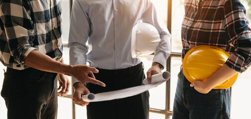 Engineer people meeting working in modern office for discussing, engineering .Hands of Engineer working on blueprint Construction concept.