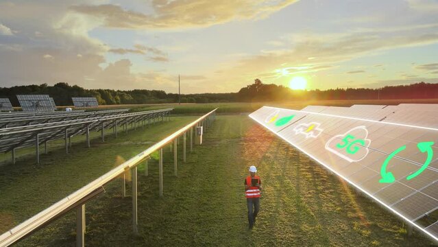 Engineer walking in photovoltaic power station checking with tablet the efficiency of solar panel while 5G electric car logo being displayed with motion graphic, alternative sustainable green energy