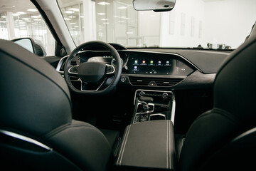 Fototapeta na wymiar Dark luxury car Interior - steering wheel, shift lever and dashboard. Car interior luxury
