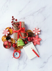 Christmas decorations, gingerbread cookies, gift box, alarm clock and notepad with pencil on marble table. Christmas holiday background. festive winter season. minimal style. Flat lay. copy space