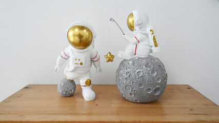 Plastic figurine of an astronaut in a spacesuit. Children's toy astronaut. Fascination with space, the study of planets. On wooden table © Spezia