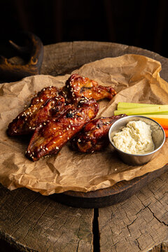 Chicken wings in teriyaki sauce with sticks of carrots, celery with sour cream sauce