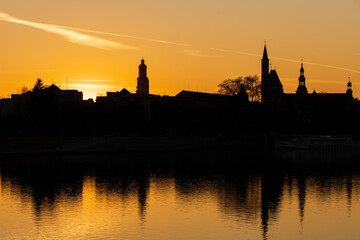 Fototapeta premium Sunset view of Oder river, embankment and church silhouettes. Wroclaw, Poland.