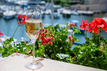 Drinking of French brut champagne sparkling wine in glasses in yacht harbour of Port Grimaud near Saint-Tropez, French Riviera vacation, France