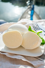 Tasting of white soft italian balls mozzarella cheese made from buffalo cow milk