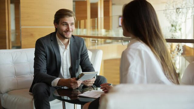Businessman giving businesswoman some very important advice. Two well dressed businesspeople having a serious discussion in their corporate office. Two employees, workmates discuss new project