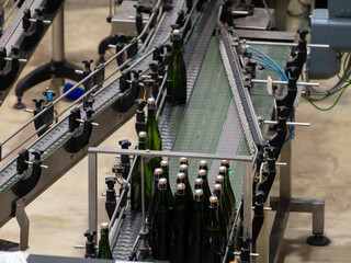 Production of cremant sparkling wine in Burgundy, France. Automatically powered bottling and riddling lines on factory.