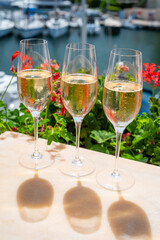 Drinking of French brut champagne sparkling wine in glasses in yacht harbour of Port Grimaud near Saint-Tropez, French Riviera vacation, France