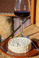 French wine and cheese pairing, glass of red beaujolais wine served with Saint-Félicien cow's milk...