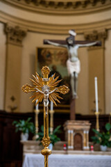 detail of a golden crucifix with jesus behind