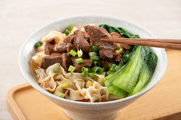 Beef noodle soup. Taiwanese famous food in a bowl on wooden table.
