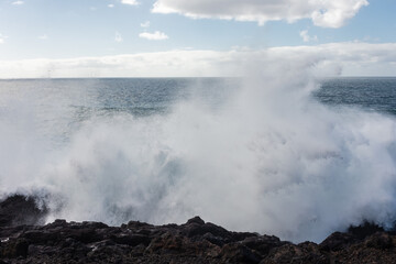 Powerful waves of the Atlantic Ocean crashing on the volcanic cliffs of Los Hervideros in Lanzarote,  Canary Islands, Spain