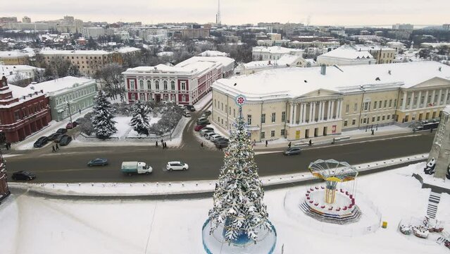 Aerial view, Christmas tree in the city square with beautiful toys and garlands. New Year's, green spruce fabulously decorated and covered with snow. City of Vladimir, Cathedral Square, Russia. UHD 4K