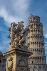 Fototapeta na wymiar Classical statue in front of the Leaning Tower of Pisa, Italy