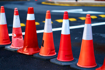 A number of red traffic cones, limiting the passage