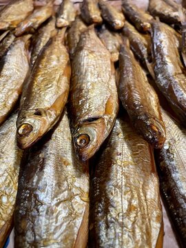 large vertical photo. close-up on smoked northern fish. vendace. bad smoked food. fat fish. eco. bio