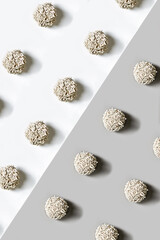 Flat lay photo of the cat litter put in the geometric pattern on the white-gray background.