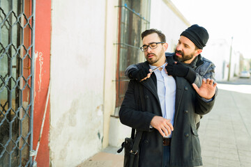 Homeless robber mugging a young man with a knife to buy food