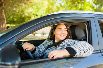 Cheerful young woman driving her car