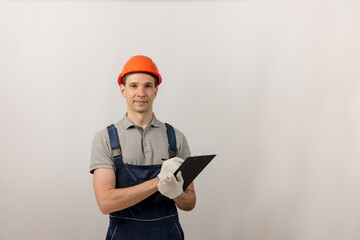 Repair work and construction concept. Male construction worker with clipboard.