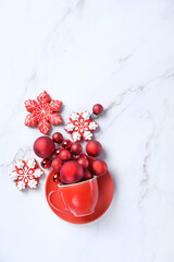 Christmas red balls in cup and gingerbread snowflakes cookies on abstract marble background. Christmas holiday concept. festive winter season. minimal style. flat lay. copy space