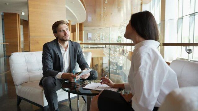 Businessman giving businesswoman some very important advice. Two well dressed businesspeople having a serious discussion in their corporate office. Two employees, workmates discuss new project