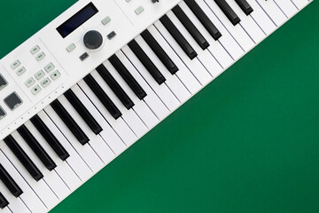 Music background with music keys on a green background, flat lay, copy space.