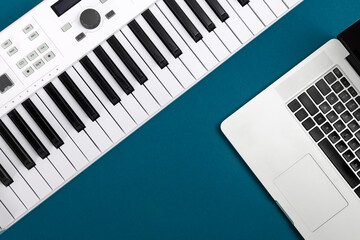 Fototapeta na wymiar Music keys and laptop on a blue background, flat lay, copy space.