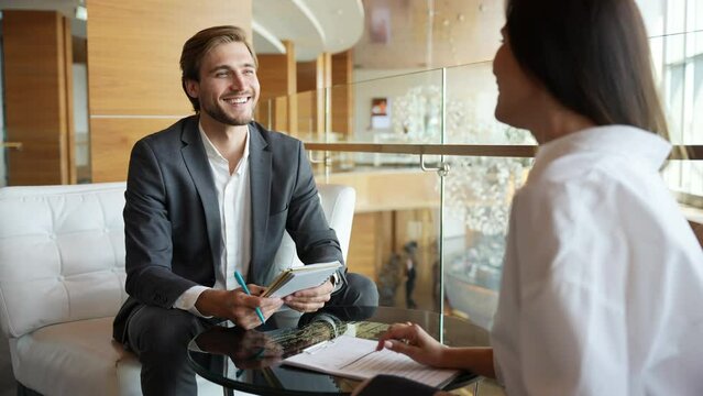 Businessman giving businesswoman some very important advice. Two well dressed businesspeople having a serious discussion in their corporate office. Two employees, workmates discuss new project