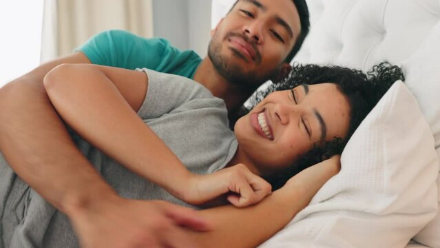 Couple, talking and happy cuddle in the bed to relax and rest while at home to sleep. Bedroom, man and woman or happy couple snuggling with romance in a loving, caring cosy relationship