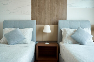 Apartment interior hotel with two single beds and bedside lamps