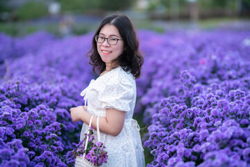 Portrait of asian Young woman happy traveler with white dress enjoying in white blooming or purple...