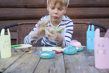 The day before Easter, beautiful child painting eggs