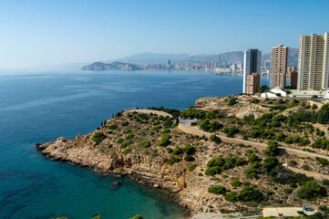Panorámica de la ciudad de Benidorm con sus alto edificios y sus verdes montañas a un lado junto...