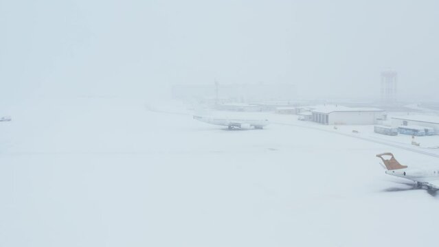 Snowy winter conditions at Keflavik airport with low visibility, aerial