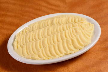 Fototapeta na wymiar Mashed potatoes. Small portion in white bowl on wooden background.