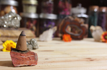 Incense Cones and Chakra Stones With Flowers in Background Shallow DOF