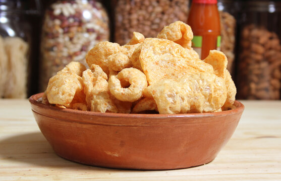 Fried Pork Skins With Hot Sauce in Rustic Kitchen