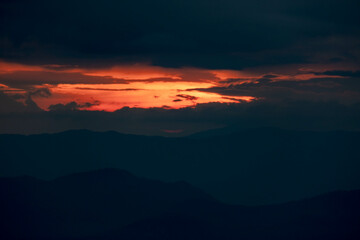 Time lapse of the beautiful sunset scenery on the top of the mountain. Aerial view of beautiful tropical valley silhouettes with the last rays of the sun. Dramatic sundown landscape.