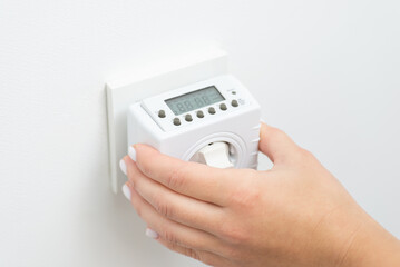 Turning on outlet computer that counts and saves energy, turns on and off socket. Plug in the...