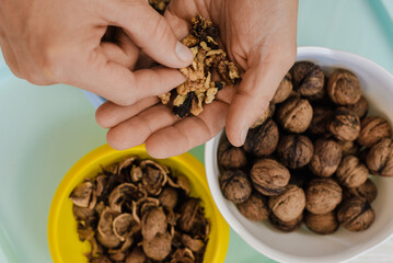 Closeup of young man holding peeled walnuts in hands