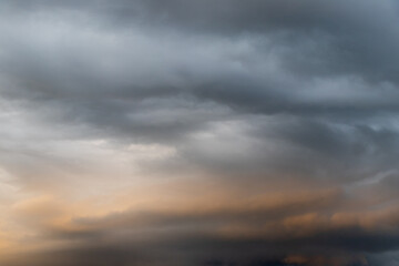 Dark cloud before raining storm and have the orange cloud that reflect light from sunset as background