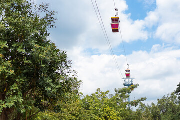 red cable car are floating on a sling for transportation by visitors and travelers who came this Theme Park and look around for environment above high view.