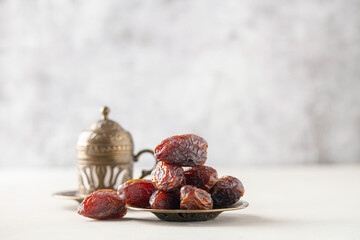 Cup of coffee and dry dates on saucer ready to eat for iftar time. Islamic religion and ramadan concept.