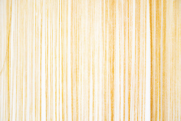 Thin golden silky yarn arranged finely in each line , a classy curtain, which is suitable for use as a beautiful backdrop in photography.
